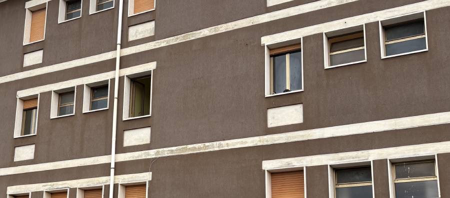 La finestre del secondo piano, un aperta, l'altra con le scarpe sul davanzale